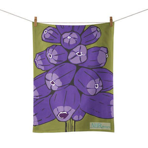 Colourful gift – Purple and Green Muscari flower design floral tea towel hanging from clothesline, white background. Designed by Anne Harrington Rees. Designed, printed and made in Ireland.