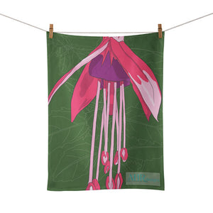 Colourful gift – Pink, Purple and Green Fuchsia flower design tea towel hanging from clothesline, white background. Designed by Anne Harrington Rees. Designed, printed and made in Ireland.