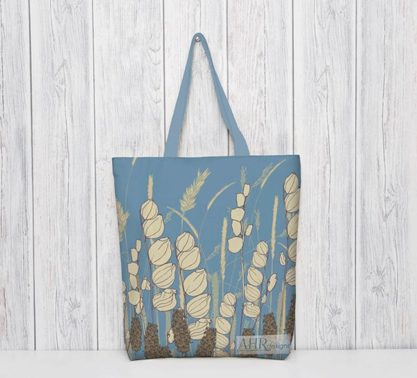 Colourful gift – Blue and Cream Meadow Sky tote bag with blue handle hanging in front of bleached wooden panel. Designed by Anne Harrington Rees. Designed, printed and made in Ireland.