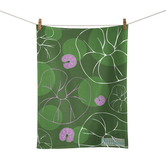 Colourful gift – Green, Pink and White Sea Bindweed flower design tea towel hanging from clothesline, white background. Designed by Anne Harrington Rees. Designed, printed and made in Ireland.